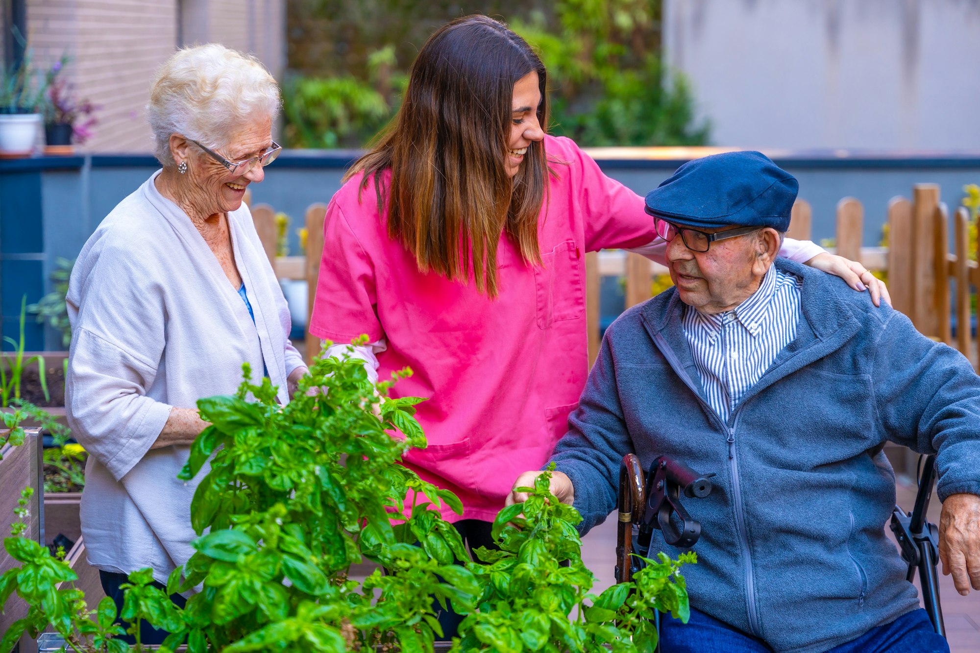Nurse and elder people in vegetable garden in a geriatric